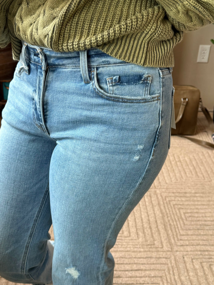Light blue denim jeans close-up of front pocket and frayed knee distress