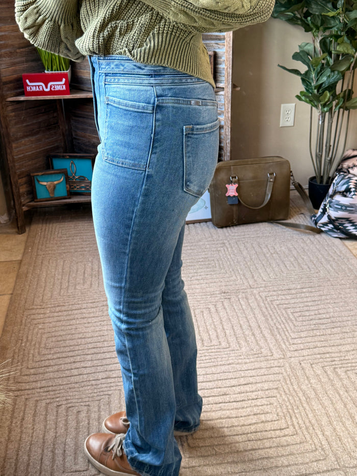 Women's light blue boot-cut jeans with patch pocket details and ankle-length flare