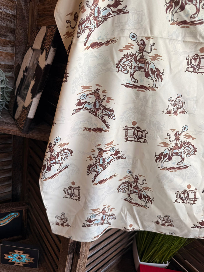 Cream wild rag scarf fabric with brown western rider and saddle motif, close-up