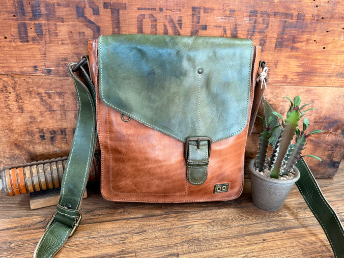 Rustic crossbody purse with green flap and tan leather, front buckle strap and pocket.