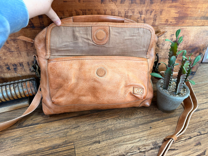 Tan leather crossbody purse back with zipper pocket and circular leather emblem