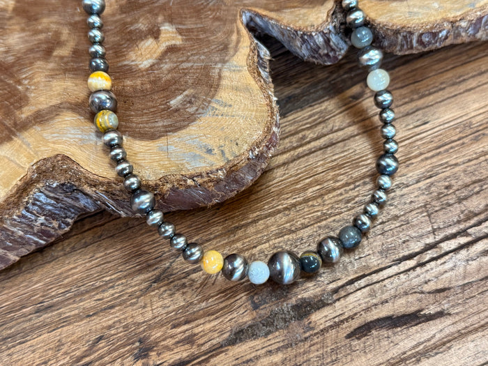 Beaded necklace close-up with pearl-like stones and jasper accents on silver links