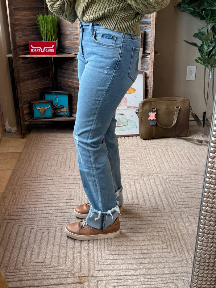 Light blue cuffed straight jeans with stacked ankle cuffs and knee rips