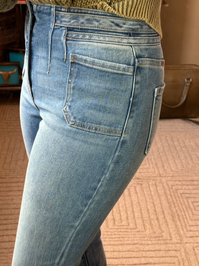 Women's light blue boot-cut jeans side view with large patch pocket and stitching