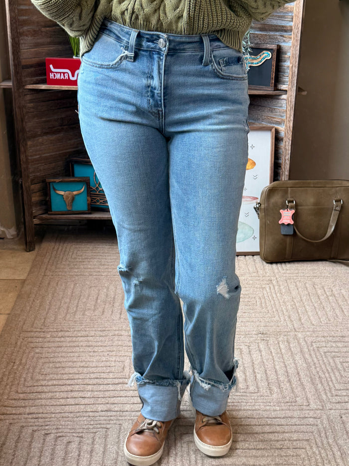 Light blue straight jeans with distressed patches at knees and cuffed hems