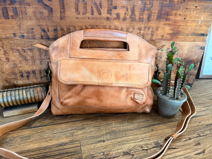 Tan rustic leather crossbody purse with top handle, front flap, and long strap