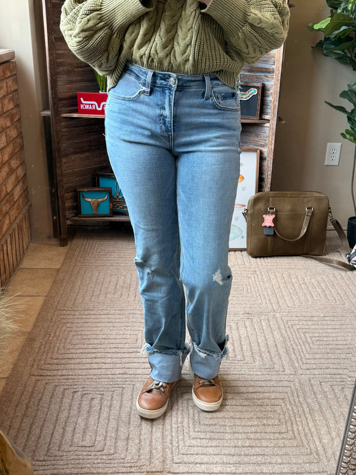 Light blue cuffed straight jeans with ripped knees and button fly