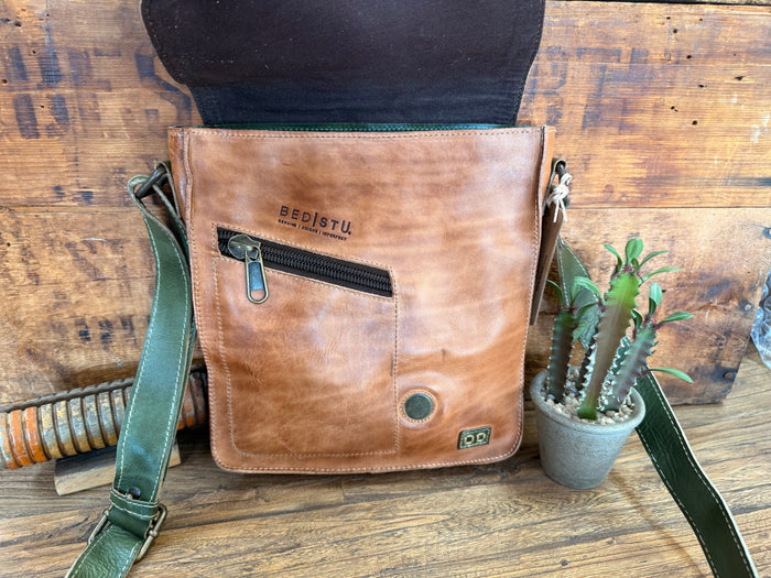 Tan leather crossbody purse back with zip pocket, round snap, and adjustable green strap.