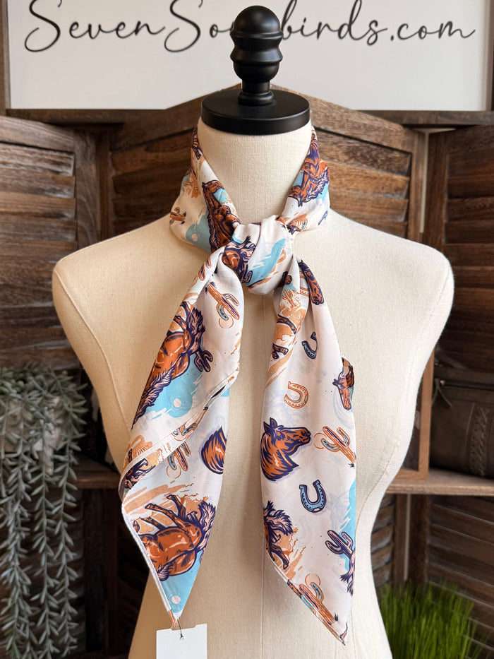 Wild Rag scarf draped on mannequin, desert horse pattern with blue and orange accents
