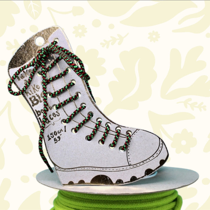 Ark paper boot with red, green, black Big Boot Laces on neon green cord; dreamy branded backdrop for trendy footwear lovers.