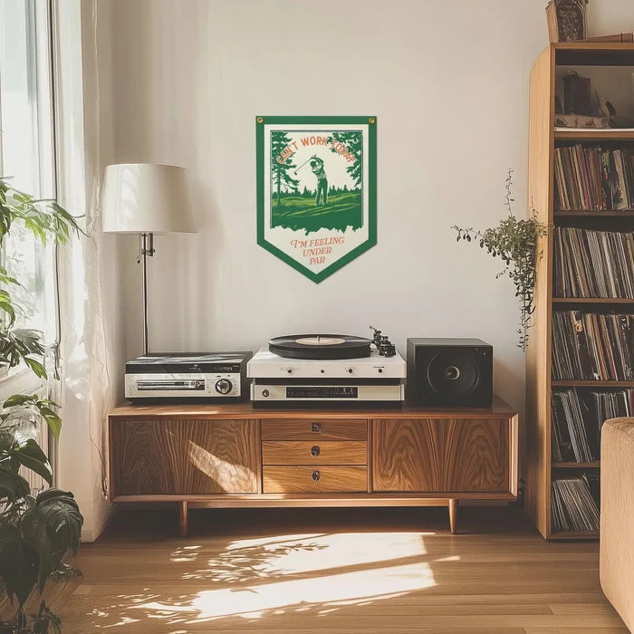 Mid-century wooden console with record player, speakers, plants, and Under Par flag—stylish home decor and vinyl setup.