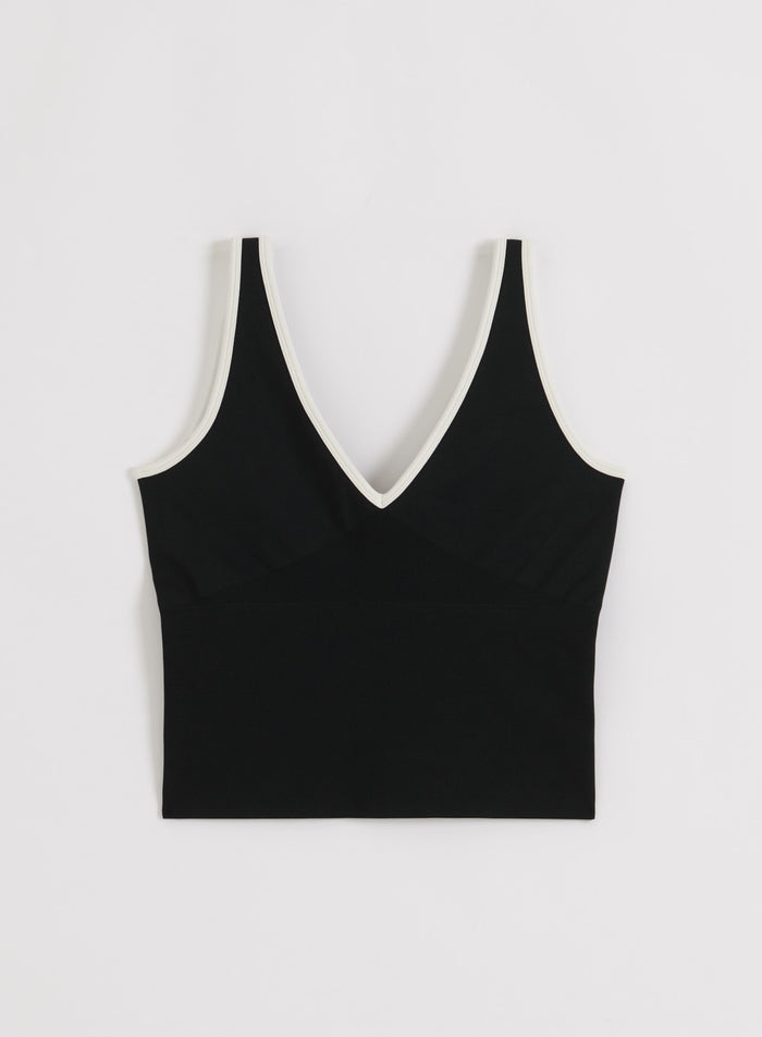 Musta-kermanvärinen aim'n Shape Seamless Deep Cut Singlet syvällä V-aukolla ja kontrastireunuksella.