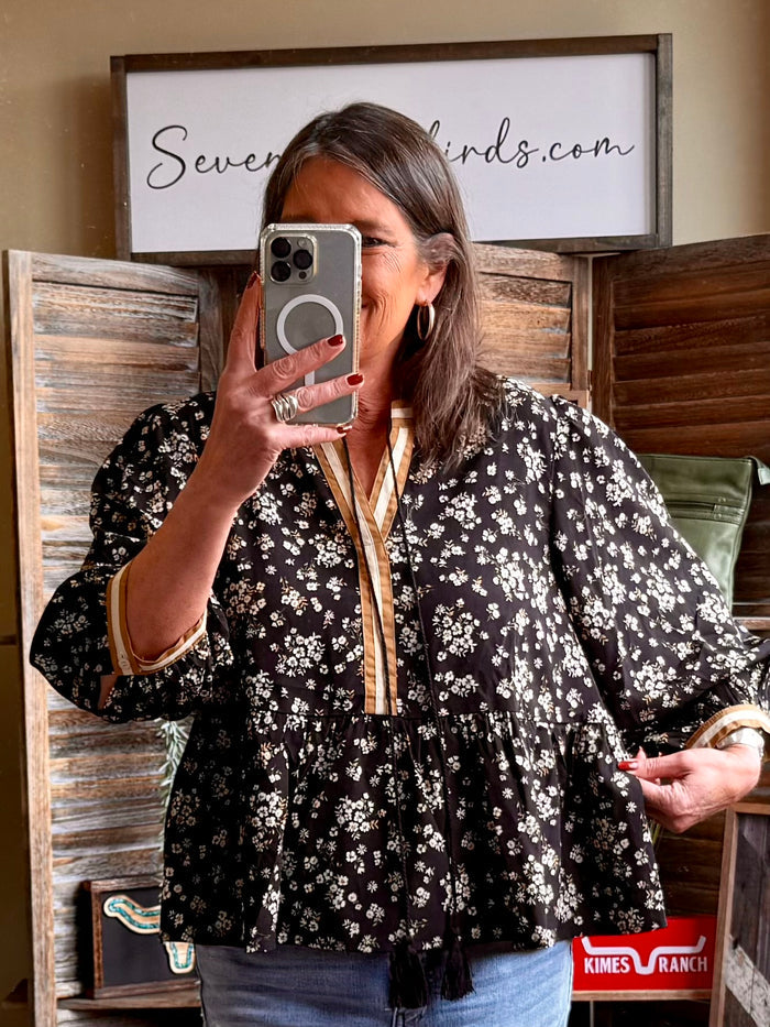 Black floral 3/4 sleeve button-front blouse with gathered peplum hem