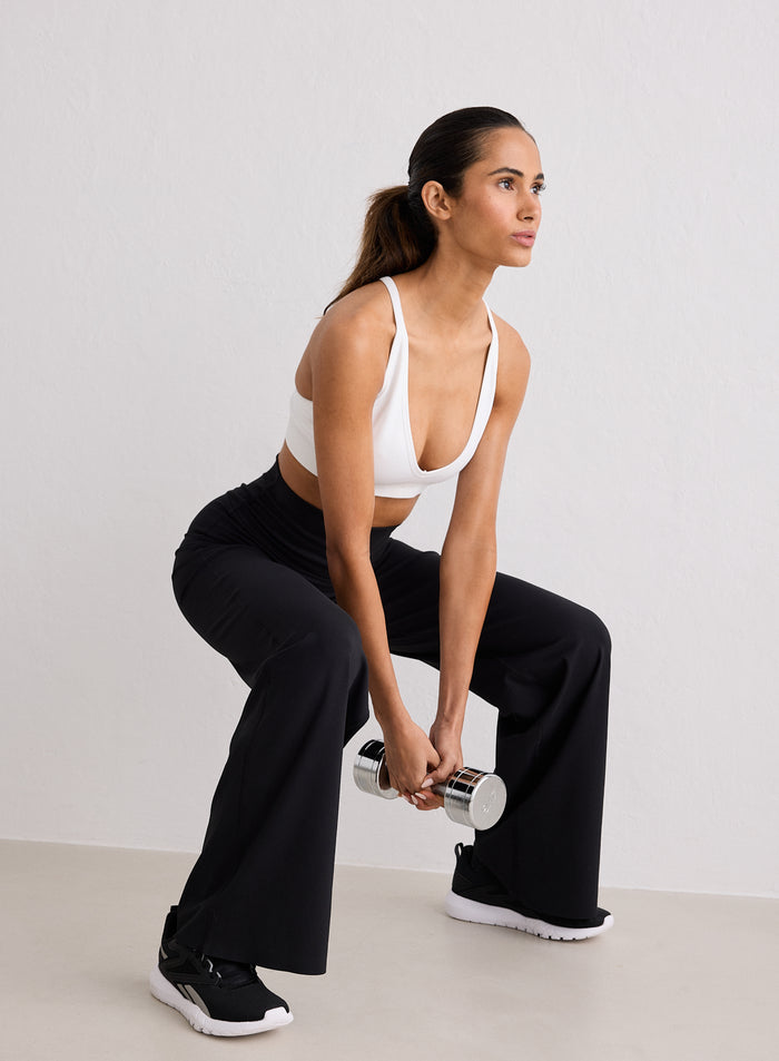 Malli yllään aim'n mustat Sense Straight Leg Tights -trikoot pitelemässä käsipainoa kyykkyasennossa [S-170cm]