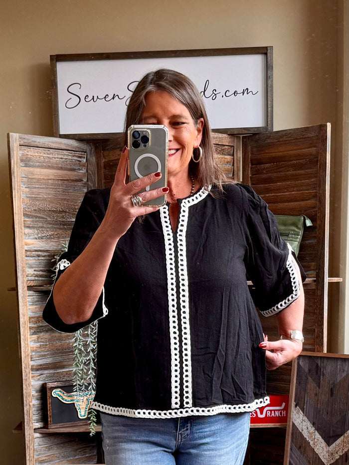 Black linen-blend shirt with white lace trim and short puff sleeves