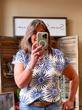 V-neck short-sleeve shirt with blue circular sunburst print on white fabric