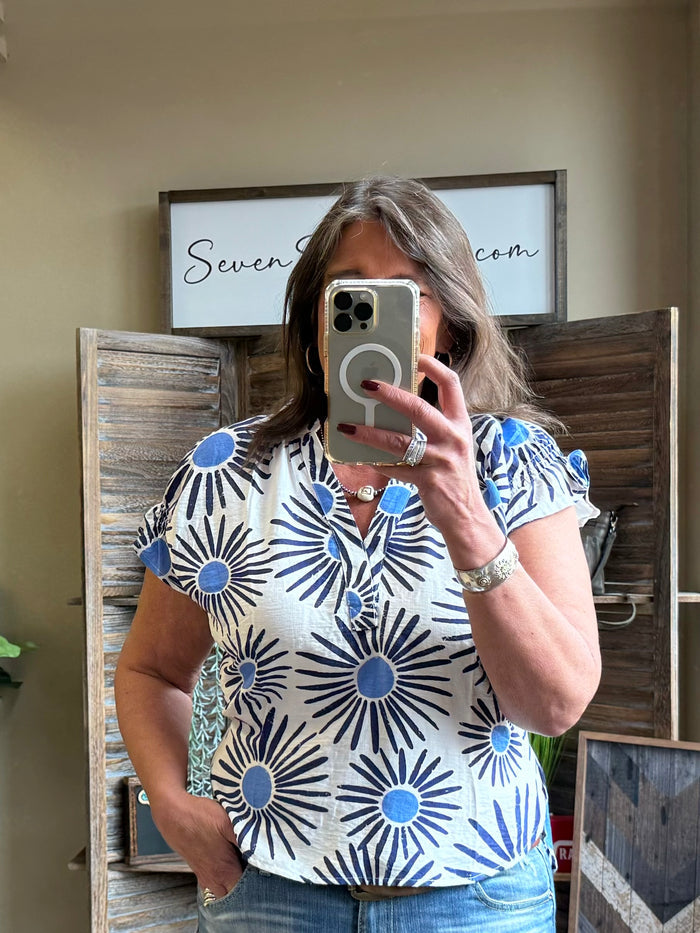 Blue and white sunburst V-neck short-sleeve shirt with bold circular swirl pattern