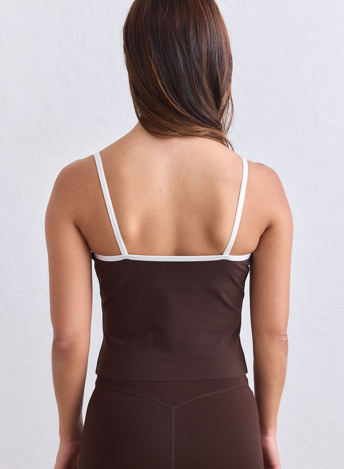 aim'n suklaanruskean singlet-topin takanäkymä, ohuet valkoiset olkaimet ja logo selässä. [S-165cm]