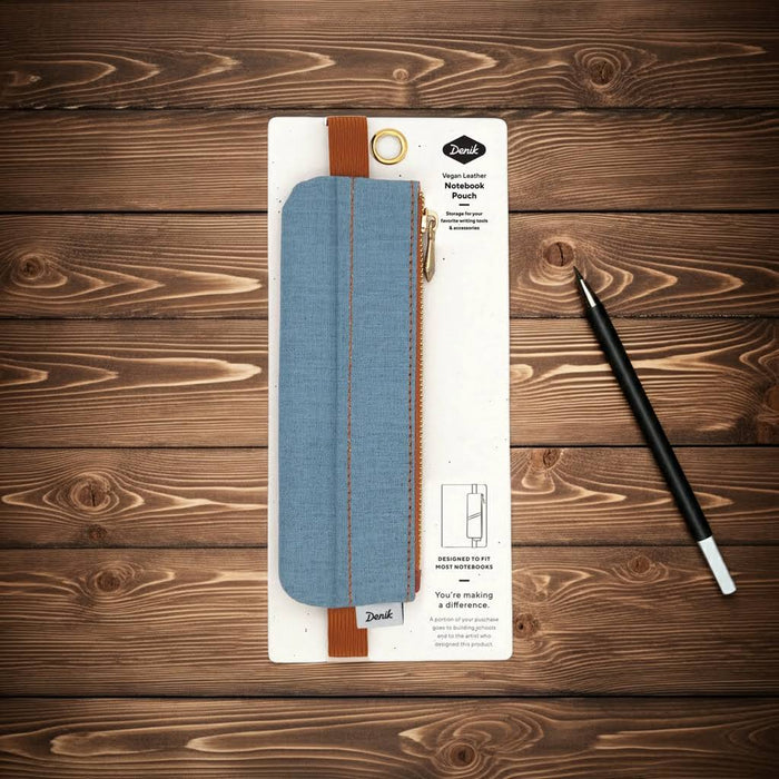 Denik Denim Distressed Blue Notebook Pouch on packaging with black mechanical pencil on wooden surface, stylish stationery.