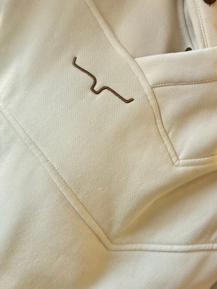Cream hoodie sweatshirt sleeve and kangaroo pocket seam close-up