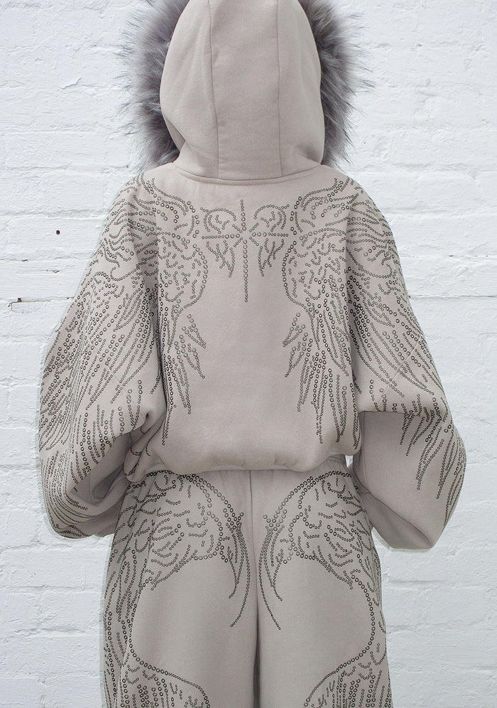 Back view of a bone hoodie with studded wing design and detachable fur trim.