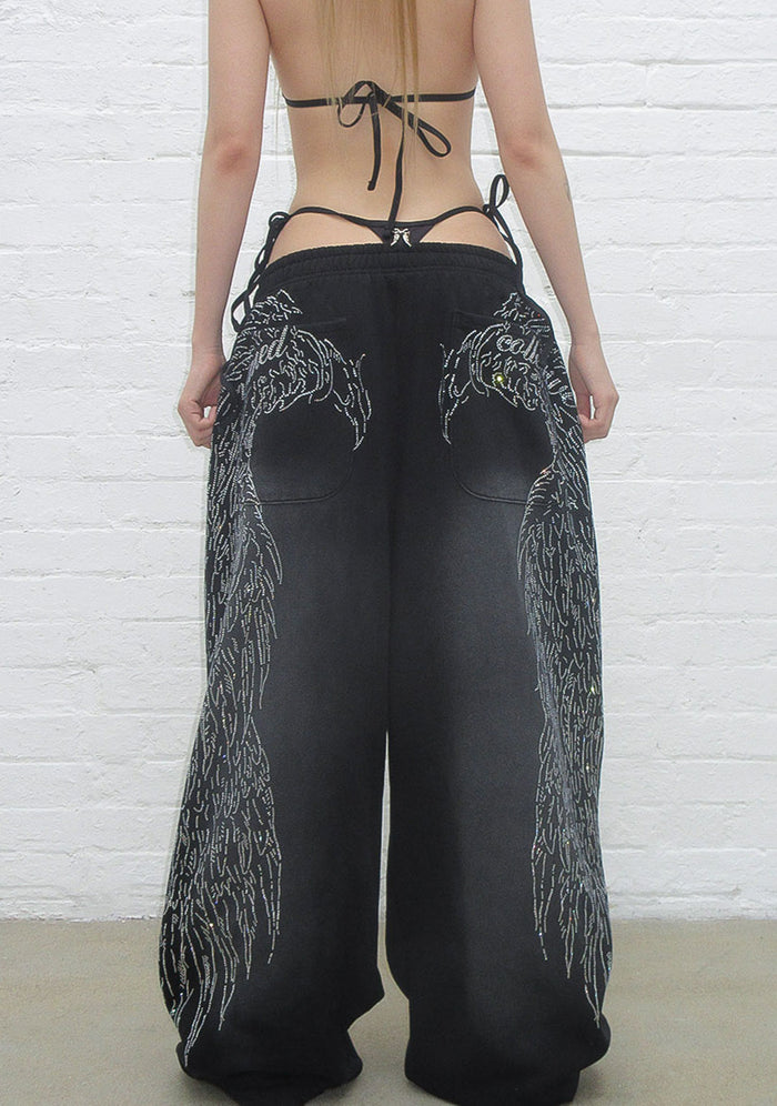 Back view of black sweatpants featuring rhinestone wing designs and two back pockets.