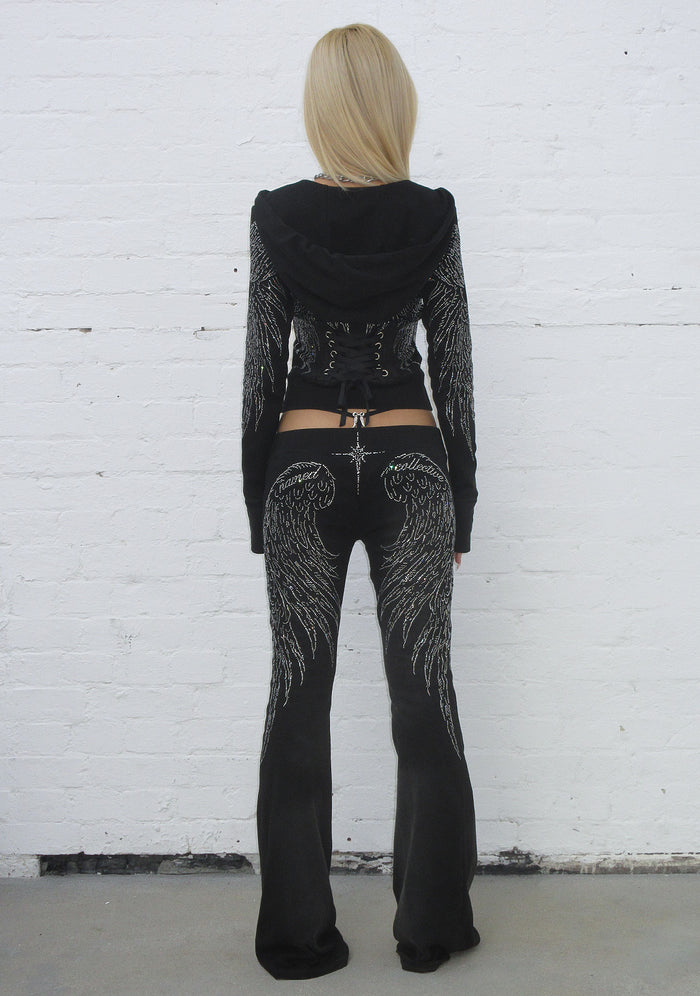 Back view of fallen rhinestone sculpt pants washed black with rhinestone wing design on the legs.
