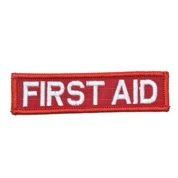 A rectangular first aid patch with white lettering on a red background.