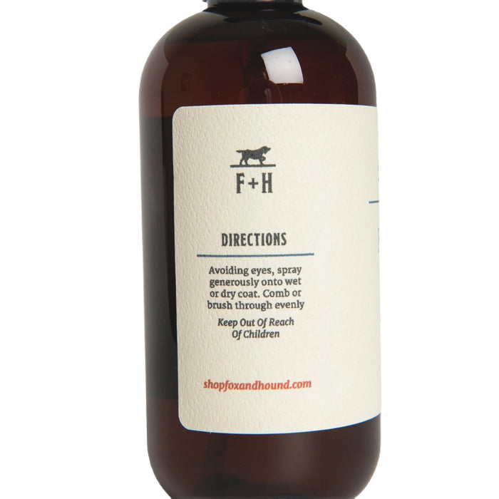 Against a plain white background, a brown bottle of Fox + Hound Dog Fragrance Spray, labeled "Redwood Amber," offers a long-lasting scent and serves as an effective pet odor solution.
