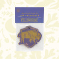 The Good & Well Supply Co Hangable Air Freshener - Yellowstone, featuring a buffalo design on a yellow and purple background, proudly supports the National Park Foundation.