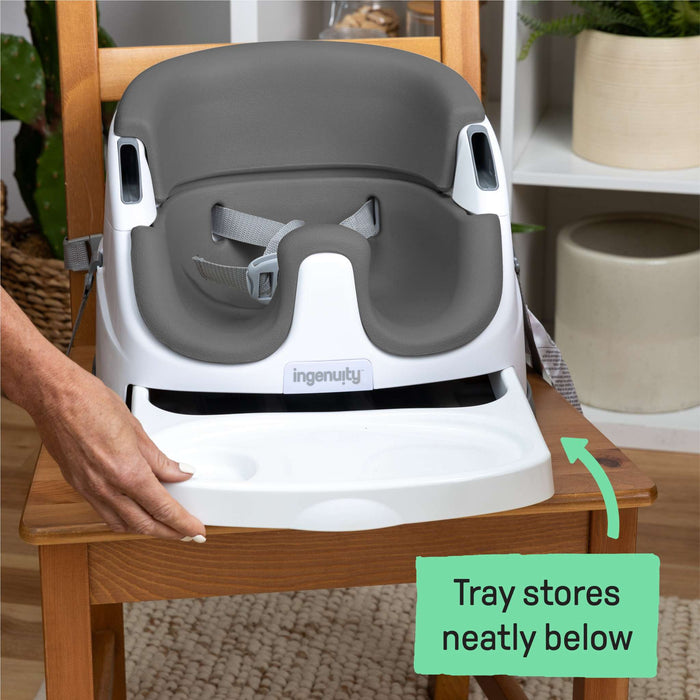 Ingenuity Baby Base 2-in-1™ Seat in Slate attached to dining chair with removable tray and foam insert for baby and toddler use