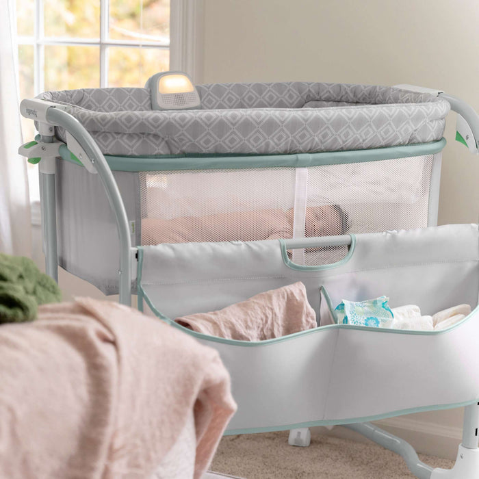 Ingenuity Dream & Grow Bedside Bassinet with breathable mesh sides, adjustable height, lockable wheels, and soothing night light