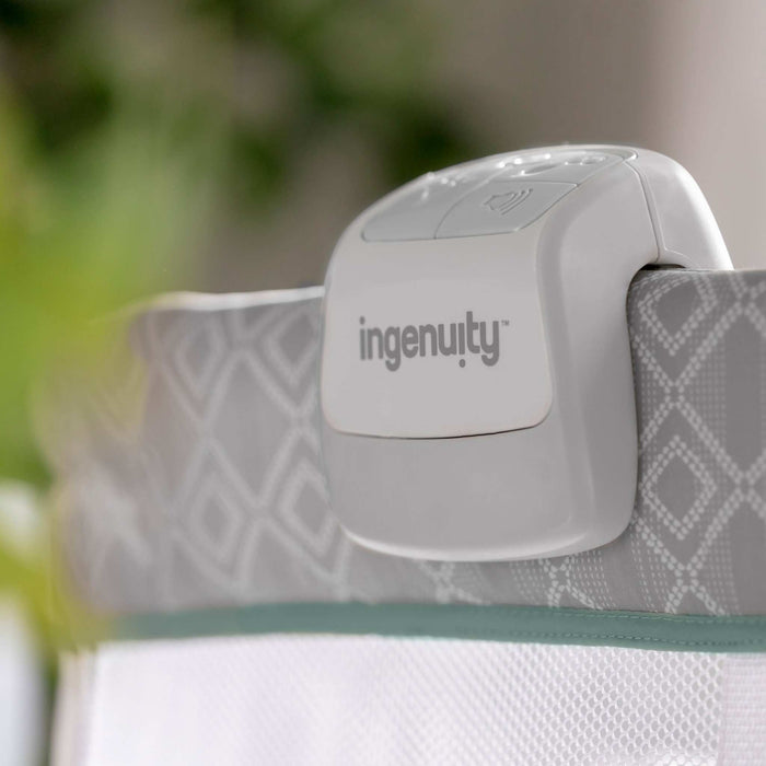 Ingenuity Dream & Grow Bedside Bassinet with adjustable height, breathable mesh sides, soothing sounds, and lockable wheels