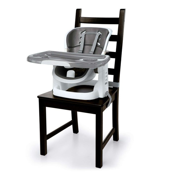 Ingenuity SmartClean ChairMate portable high chair and toddler booster seat in slate color attached to dining chair