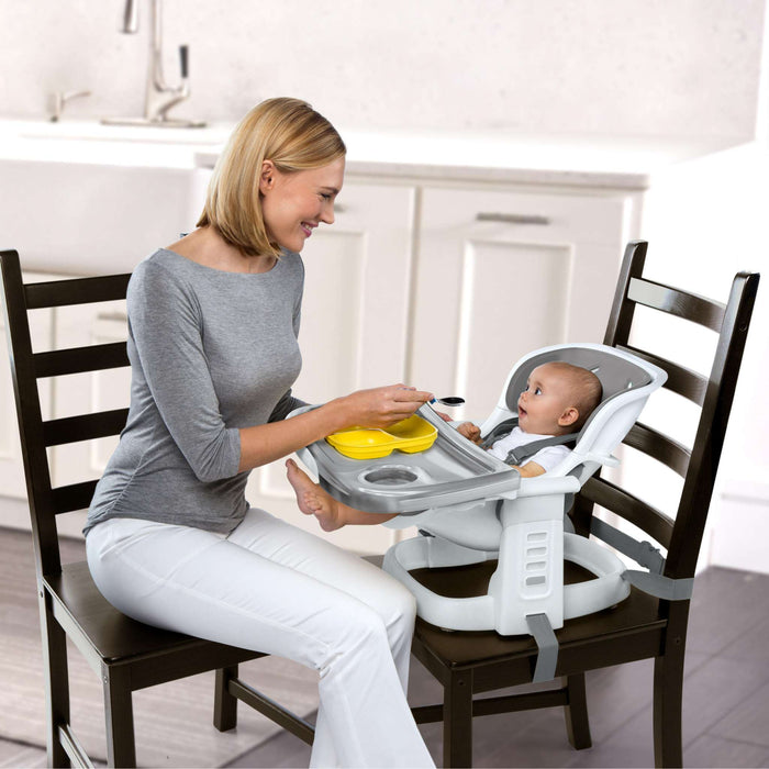 Ingenuity SmartClean ChairMate high chair and toddler booster seat in slate attached to dining chair
