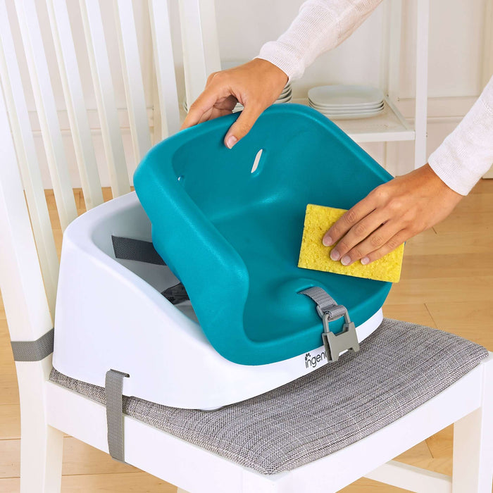 Ingenuity SmartClean Toddler Booster Seat in Peacock Blue with washable foam insert and 3-point harness attached to dining chair