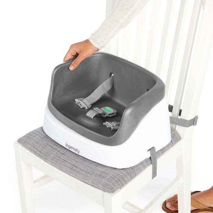 Ingenuity SmartClean Toddler Booster Seat in slate color with removable foam insert and 3-point harness for secure dining