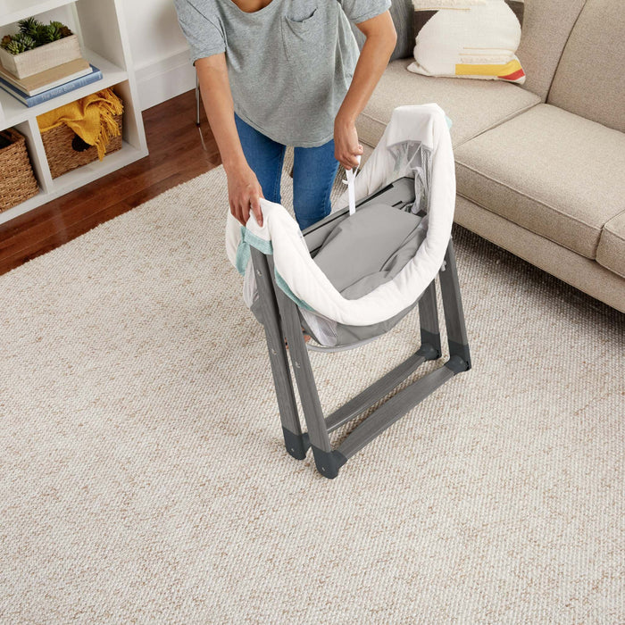 Ingenuity Wood FoldAway Rocking Bassinet with breathable fabric and foldable wooden frame in neutral design