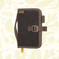 Brown Lochby Mini Field Journal, waxed canvas pouch style with handle & buckle, on floral background—perfect EDC notebook.