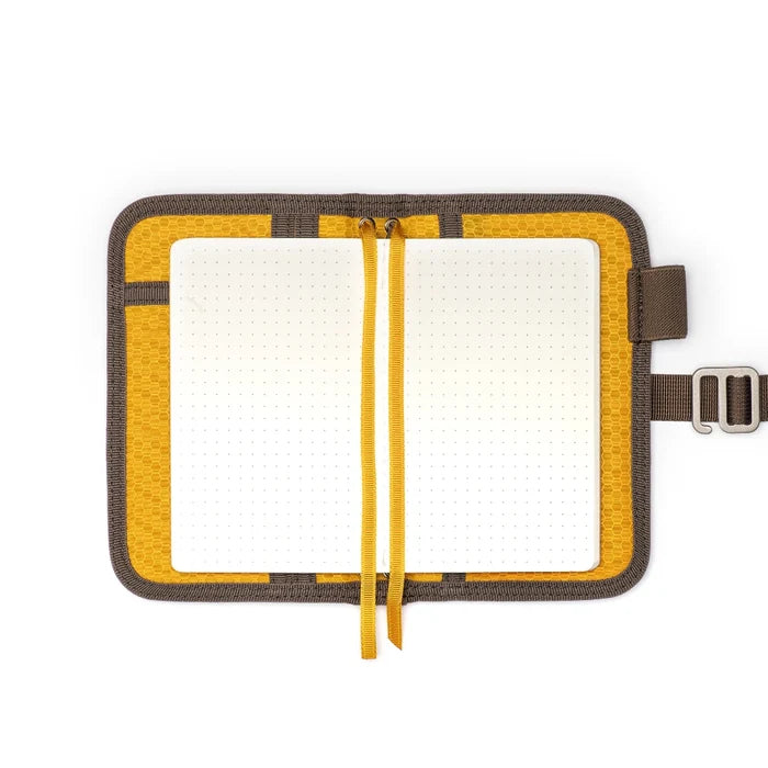 Shop the Lochby Mini Field Journal—brown waxed canvas cover, dotted grid pages, and two yellow ribbon bookmarks for notes.