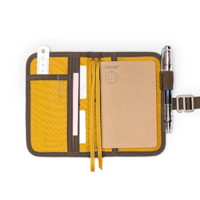 Lochby Mini Field Journal Brown in waxed canvas cover with ruler, cards, paperclip, and two pens—perfect for on-the-go notes.
