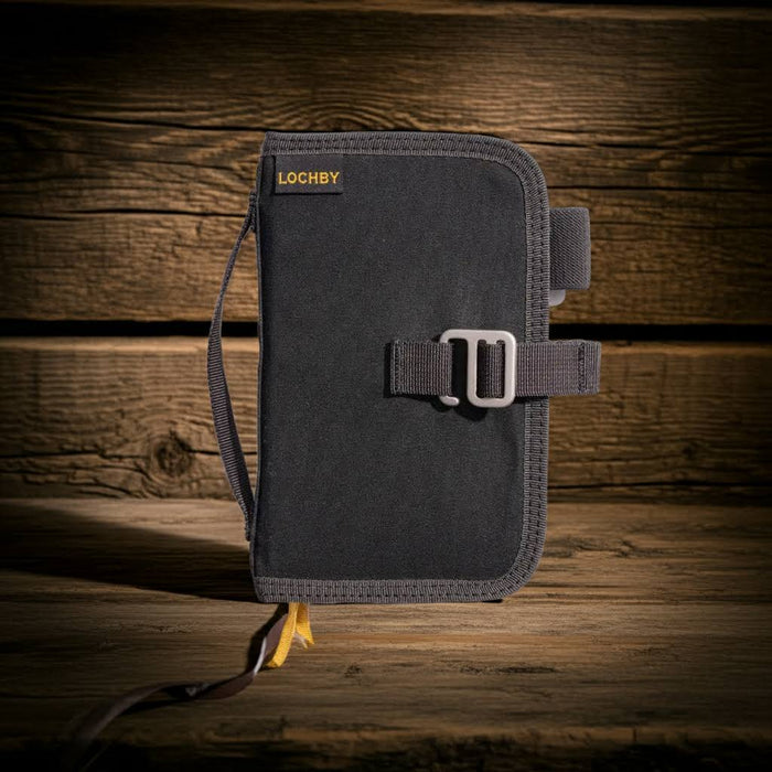 Lochby Mini Field Journal Bumblebee Charcoal stands on wood, wood plank backdrop. Durable portable notebook for writing.