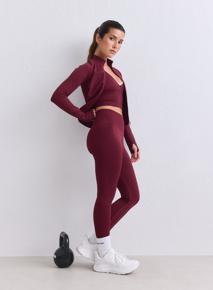Malli pukeutuneena merlot-värisiin aim'n Shape Seamless Tights -trikoisiin ja takkiin kuntosalilla. [XS-165cm]