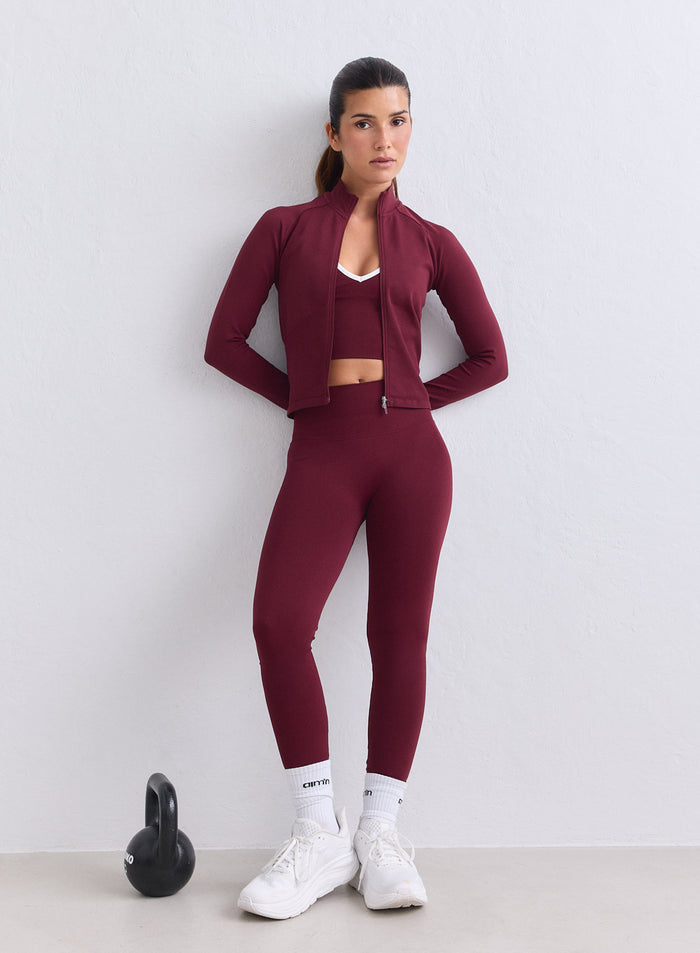 Malli yllään merlot-väriset aim'n korkeavyötäröiset Shape Seamless Tights ja takki kahvakuulan kanssa [XS-165cm]