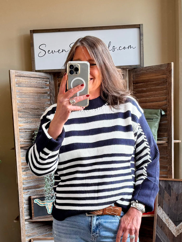 Navy and white striped knit sweater with crew neck and long sleeves, front view