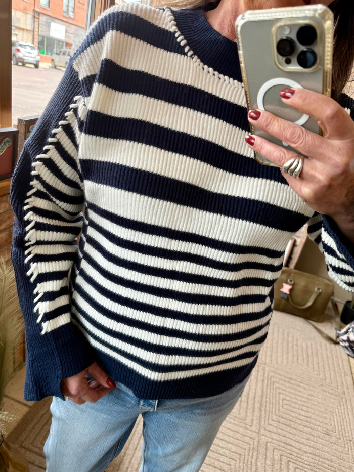 Navy and white striped knit sweater with ribbed collar and cuffs, close side view