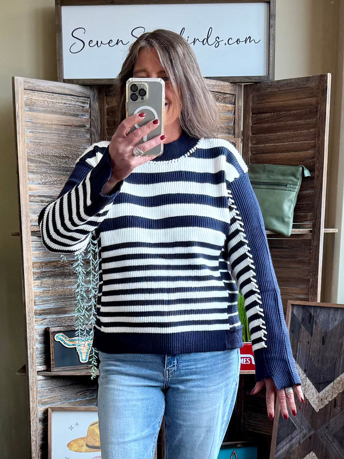 Navy and white striped knit sweater with crew neck and long sleeves, front view
