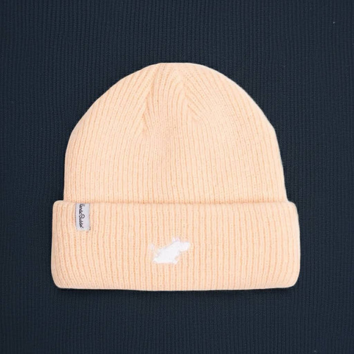 Nordicbuddies Moomin Classics peach beanie with white logo, cozy winter hat on dark textured backdrop, stylish warm accessory.