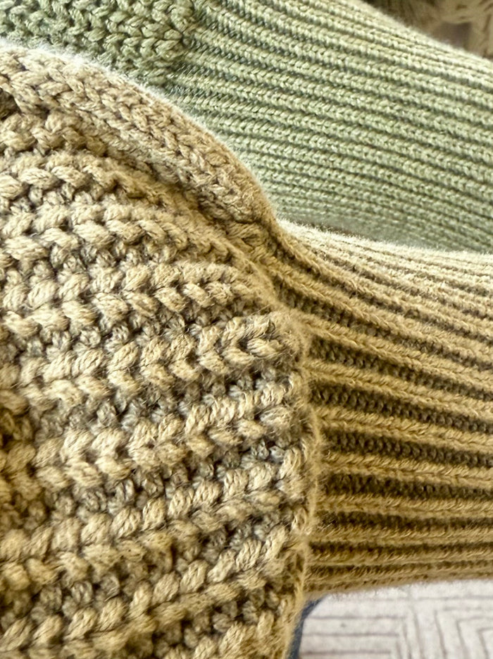 Olive cable-knit sweater knit texture with ribbed stitches and cable ridges