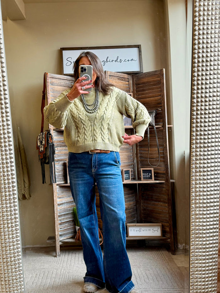 Olive cable-knit sweater with wide sleeves, ribbed hem, and crew neck